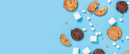 Marshmallows, cookies, blank space for text on a light blue background. Top view, flat lay. Bannerの写真素材