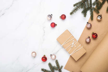 Gift, wrapping craft paper, spruce branches on a marble background. Top view, flat layの写真素材