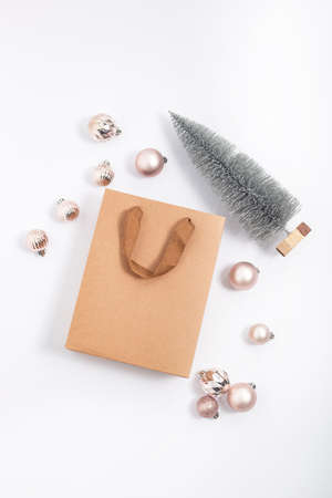 Craft gift bag, Christmas tree, decorative balls on a white background. Top view, flat layの写真素材