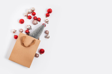 Christmas tree in a craft gift bag, decorative balls on a white background. Top view, flat layの写真素材