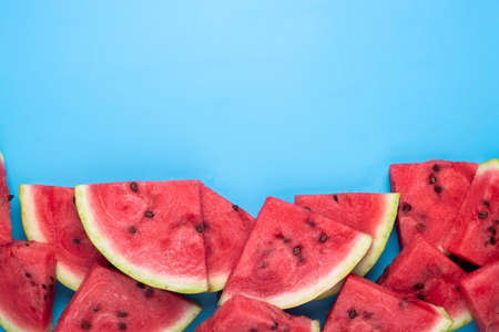 Slices of juicy red watermelon on blue. Top view, flat lay.の写真素材