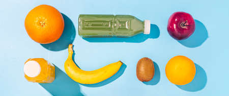 Fruits, juices detox in plastic bottles on a blue background. Top view, flat lay. Bannerの写真素材