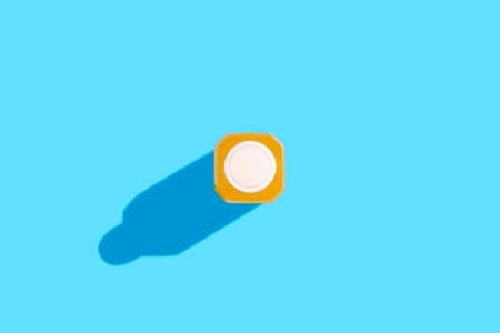 Yellow detox juice drink in a bottle on a blue background. top view, flat lay