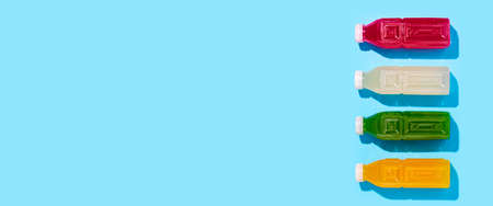 Colored detox juice drink in bottles on a blue background. Top view, flat lay. Banner