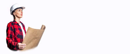 Young woman in construction clothing with a drawing on a light background. Banner