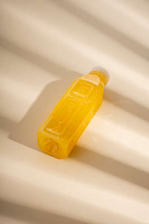 Detox drink in a plastic bottle under the rays of the sun on a light background. top view, flat lay