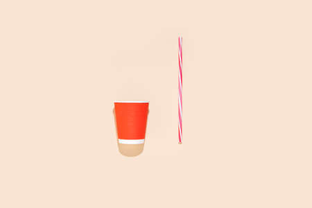 Red paper cup, straw on a beige background. takeaway. Top view, flat layの写真素材