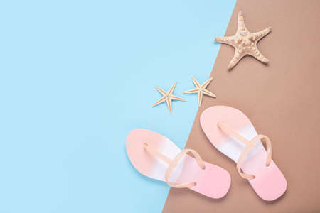 Flip flops and starfishes on a brown-blue background. top view, flat layの写真素材