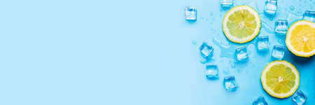 juicy fresh three lemon wedges and ice on a blue background. Top view, flat lay. Banner.の写真素材