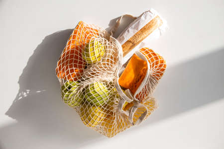 Shopping bag with food on a white table. top view, flat lay