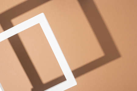 White presentation podium frame on a light brown background. Top view, flat lay.