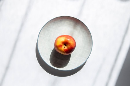 An apple on a plate on a white background. Top view, flat lay.