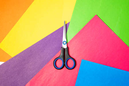 Stationery scissors lie on colored paper. Top view, flat lay.の写真素材