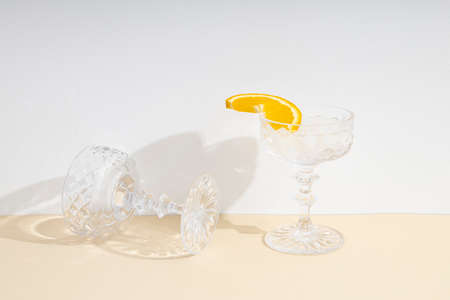 One glass with a cocktail, the other empty on the table.の写真素材