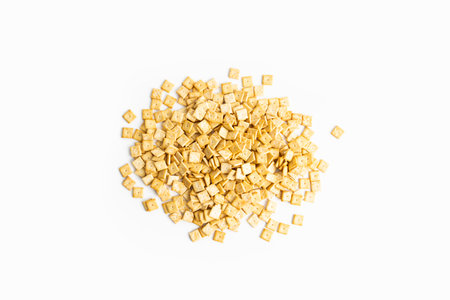 Small square cracker lies on a white background. Top view, flat lay.