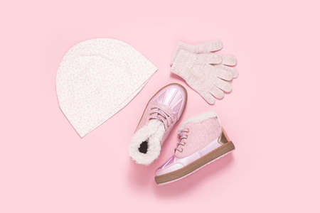 Shoes, hat and gloves for children for a girl on a pink background. Top view, flat layの写真素材