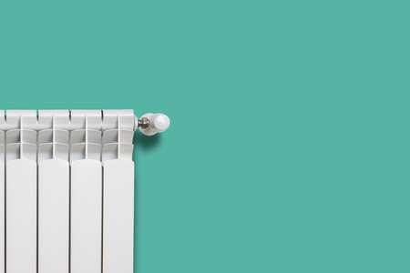 White heater with a regulator on a turquoise wall. Central heating concept.の写真素材