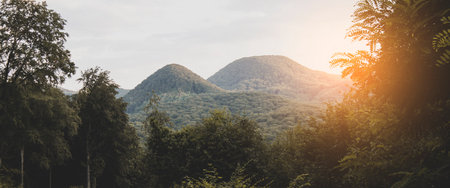 Beautiful sunset in the mountains landscape, green slopes of the mountains. Banner.