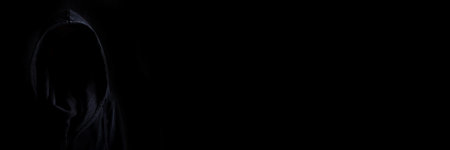 Faces are not visible in black robes in the dark on a black background. Banner.の写真素材