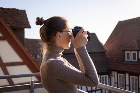 Young woman taking pictures on the camera on the street.