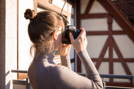 Young woman taking pictures on the camera on the street.の写真素材