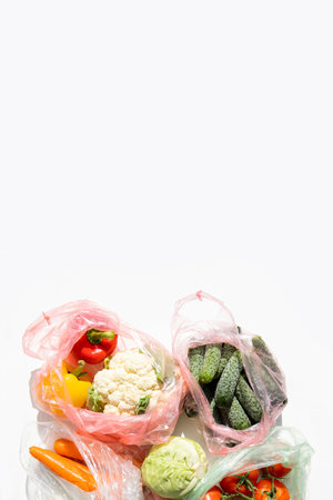 Fresh vegetables in plastic bags on a white table. Top view, flat lay.の写真素材