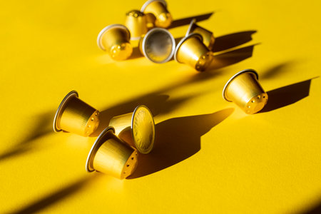 Coffee capsules under natural light on a yellow background.の写真素材