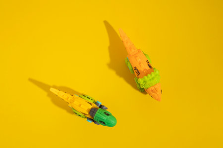 Plastic toy dinosaur on a yellow background. Top view, flat lay.の写真素材
