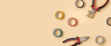 Electrical insulating tape, pliers, wire strippers on a light background. Top view, flat lay. Banner.の写真素材