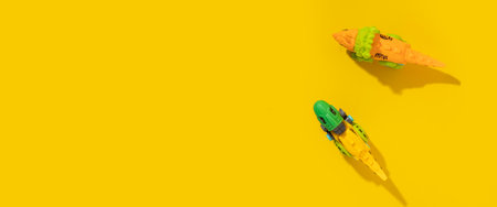 Plastic toy dinosaur on a yellow background. Top view, flat lay. Bannerの写真素材