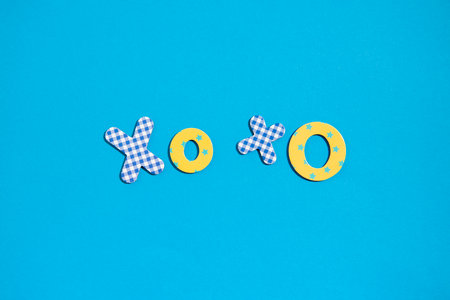 The word Xoxo from multi-colored letters of the alphabet on a blue background. Top view, flat lay.の写真素材
