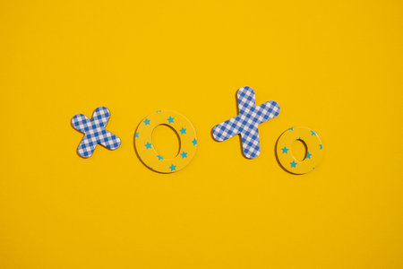 The word Xoxo from multi-colored letters of the alphabet on a yellow background. Top view, flat lay.の写真素材