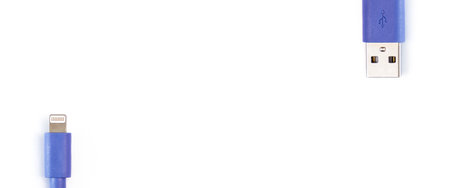 The blue USB data cable is compatible with all mobile phones on a white background. top view, flat lay. Banner.の写真素材