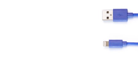 The blue USB data cable is compatible with all mobile phones on a white background. top view, flat lay. Banner.の写真素材