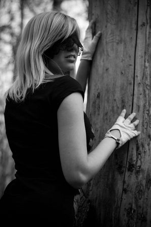 girl blindfolded beside a treeの写真素材