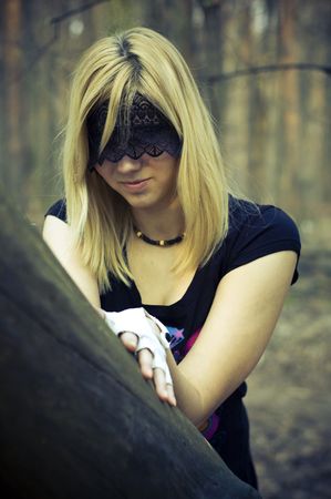 girl blindfolded beside a treeの写真素材