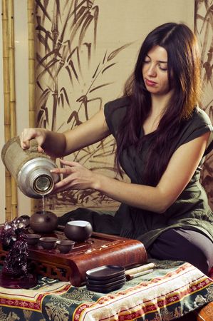 A young girl holds a Chinese tea ceremonyの写真素材