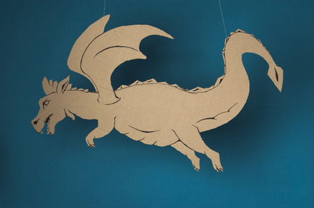 photo of dragon  made of cardboards on a blue background.の写真素材