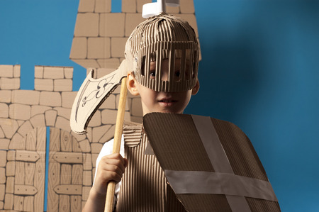 photo of the boy in medieval knight costume made of cardboardsの写真素材
