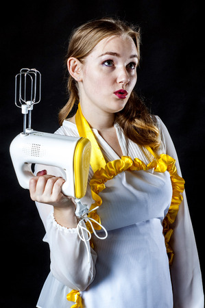 Photo of young wondering housewife with mixerの写真素材