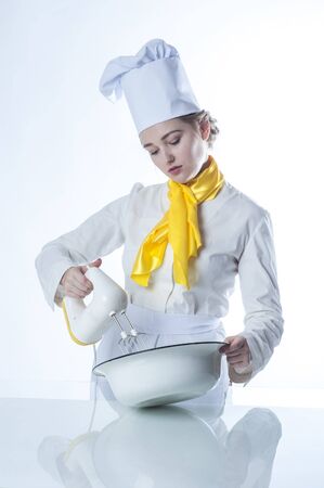 Photo of a young cook working with mixerの写真素材
