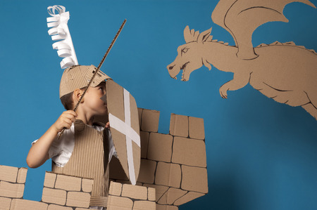 photo of the boy in medieval knight costume made of cardboardsの写真素材