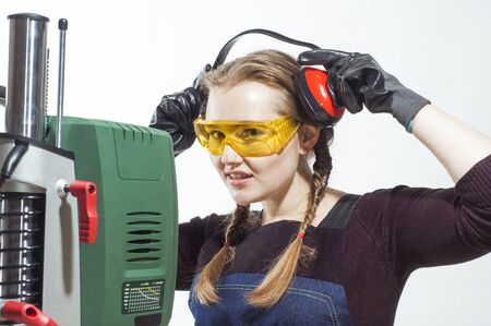 Female construction worker wearing protective headphones and level safety glasses