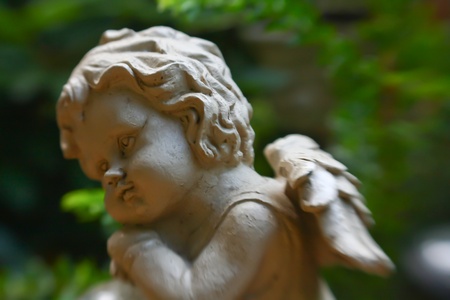 Photo with angel sculpture and green backgroundの写真素材