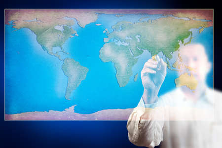 Businessman drawing a map of the world on glass