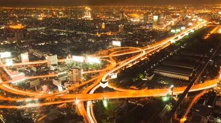Busy road intersection in the heart of downtown Bangkok, shot at night showing car headlight trailsの写真素材