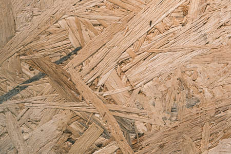 Plywood with fragments of compressed sawdust. Plywood board texture background, wood grain for...