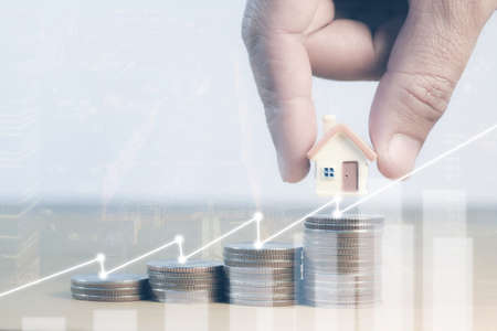 Money coins saving for concept investment mortgage fund finance and home loan refinance, savings plans for housing, house mortgage financial concept, Money coin stack with house.の写真素材