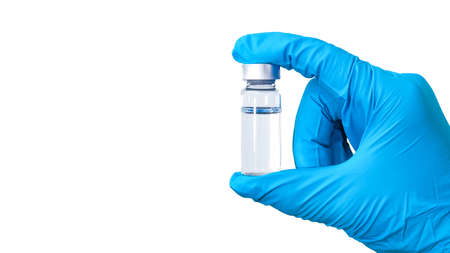 Doctor's hand in a medical glove holds a bottle with a vaccine against a white background, measles,...