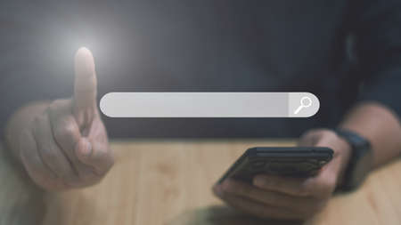 Searching information data on internet networking concept, businessman working with smartphone and stylus pen on wooden desk in modern office, Digital marketing, IoT Internet of Things, E-commerce and online shopping.の写真素材